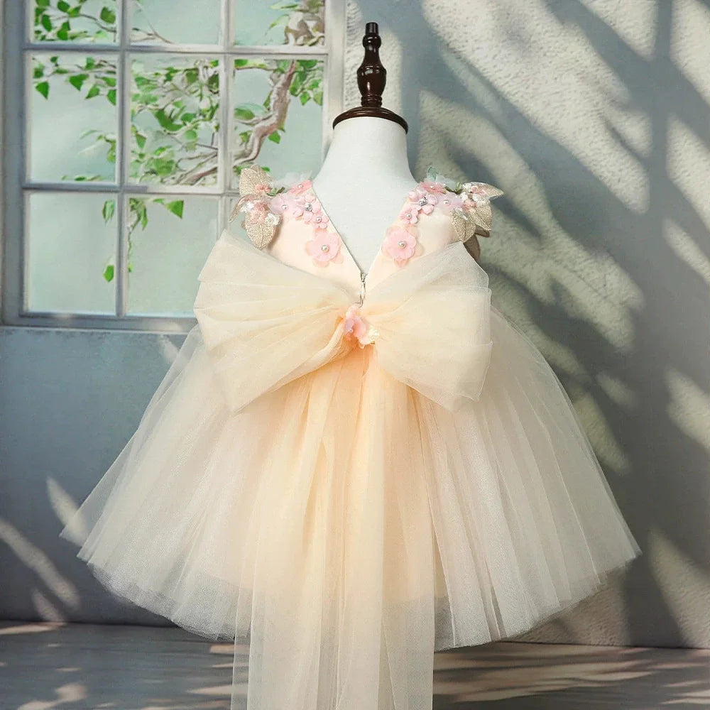 Back of the champagne flower girl tulle gown with oversized tulle bow