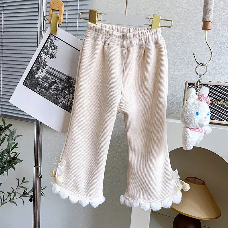 Cream girls corduroy flare pants with white pom-pom trim