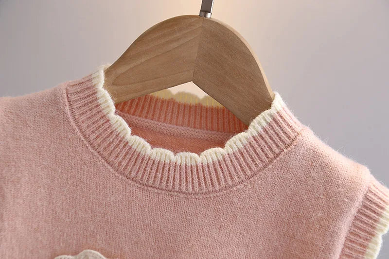 Girls knit sweater vest scalloped ruffle neckline close-up in blush pink