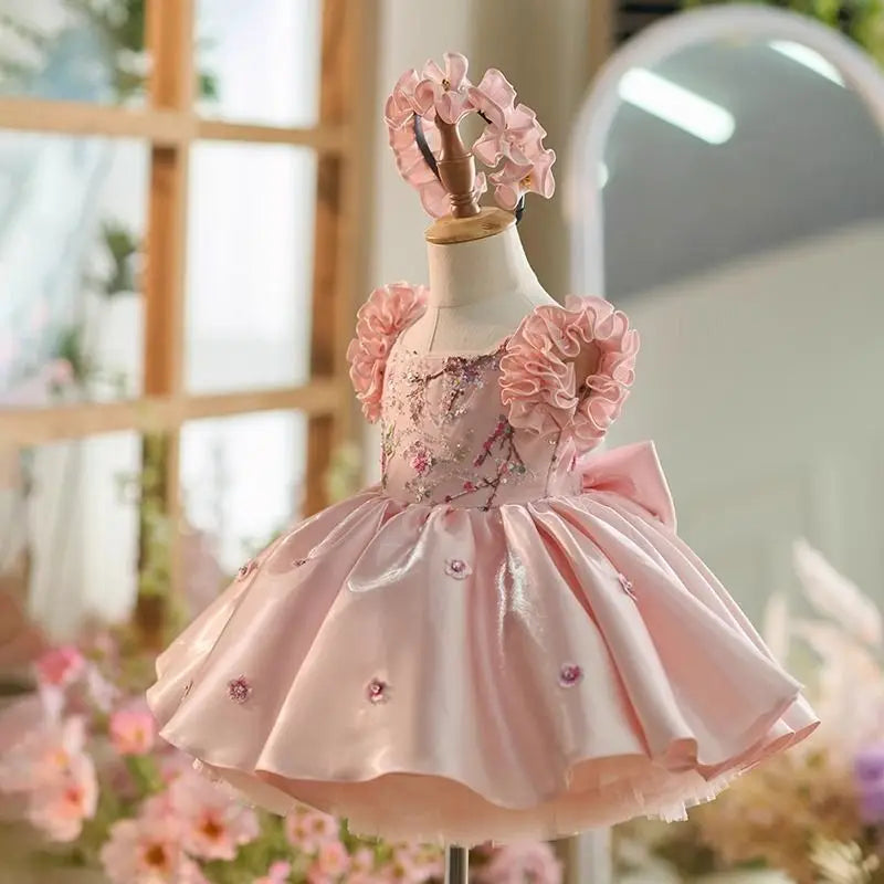 Side view of the pink satin flower girl dress showing the full skirt and big back bow