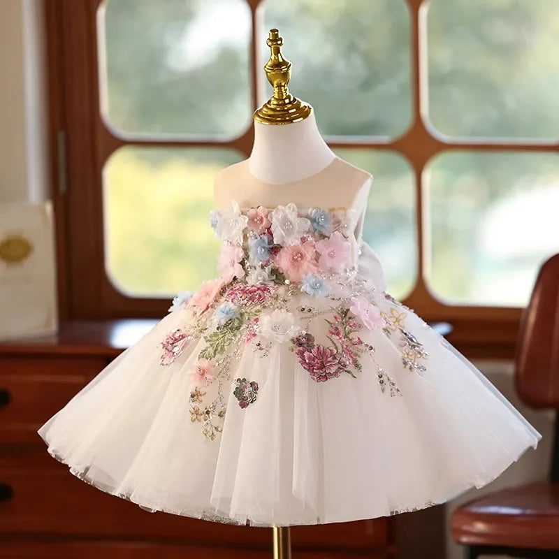 White flower girl dress with 3D flowers and sequin floral embroidery on a full tulle skirt