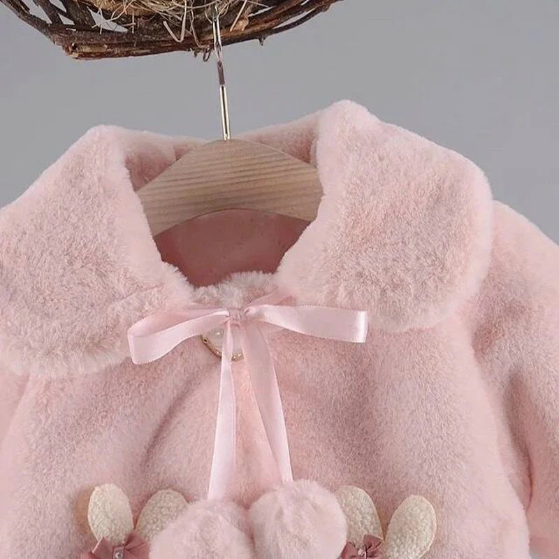 Close-up of the turn-down collar and pom-pom ribbon bow on the blush pink baby faux fur coat