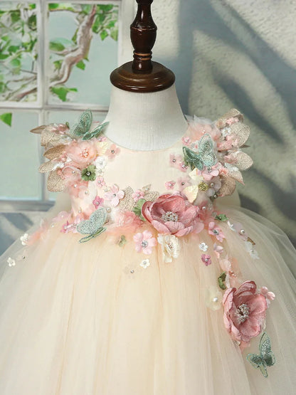 Close-up of the 3D flowers, pearls and butterflies on the champagne flower girl tulle dress