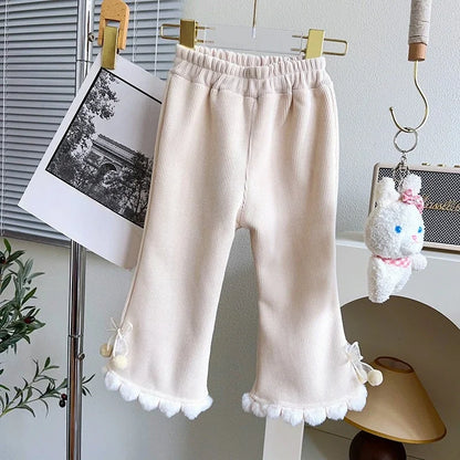 Cream girls corduroy flare pants with white pom-pom trim