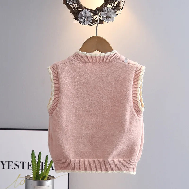 Back view of girls sleeveless knit sweater vest in blush pink with ruffle hem