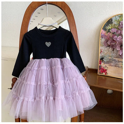 Girl twirling in a purple long-sleeve party dress